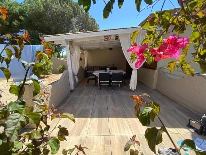 a patio with a table and some pink flowers at Casa Teresa in Porto Pino