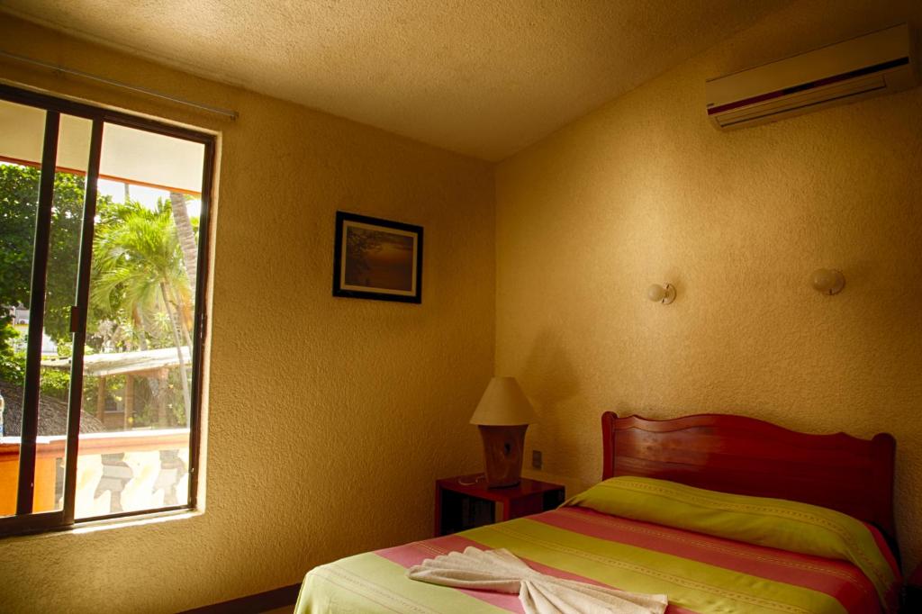 1 dormitorio con cama y ventana en Rincon del Pacifico en Puerto Escondido