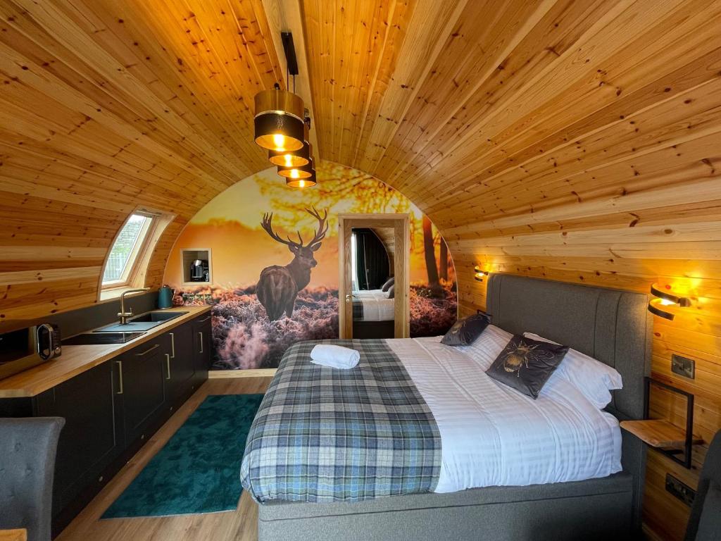 2 Sinclair bay lodges في Keiss: غرفة نوم في كابينة خشب بها سرير ومغسلة