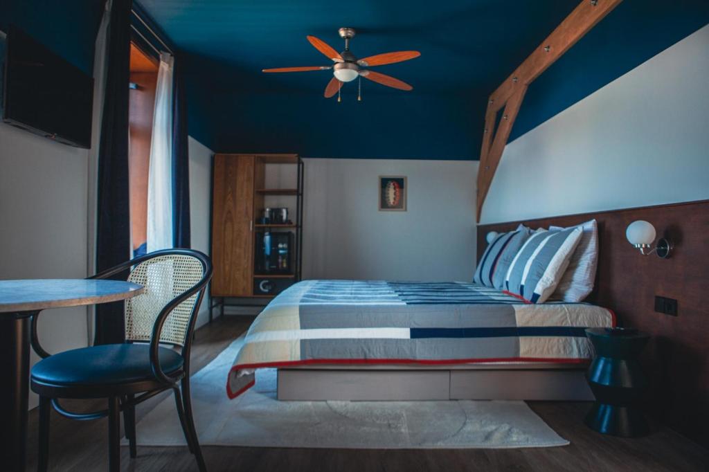 Schlafzimmer mit einem Bett und einem Deckenventilator in der Unterkunft Café Koophandel in Ouddorp