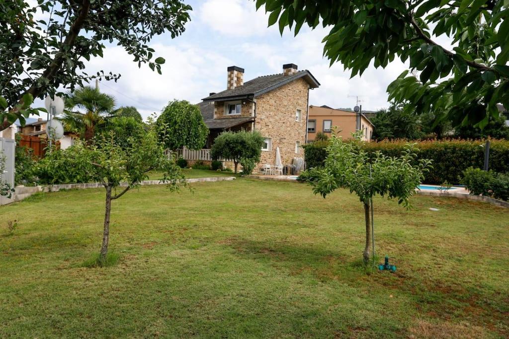 uma casa com duas árvores num quintal em Villa Albino Piscina climatizada 