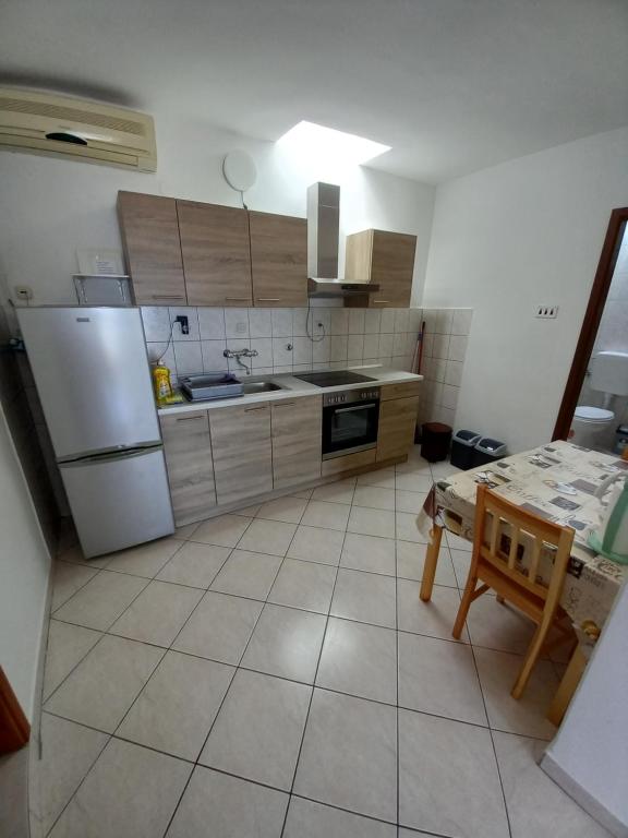 a kitchen with a refrigerator and a table in it at House Marina 30m from the sea in Sveta Nedelja