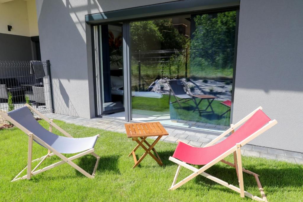 twee stoelen en een tafel in het gras bij Apartament Księżycowy z jacuzzi in Nowy Sącz