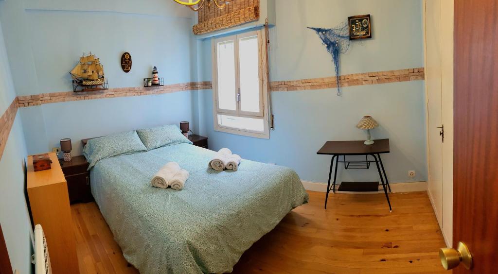 a bedroom with a bed with towels on it at Donostia Vintage House in San Sebastián