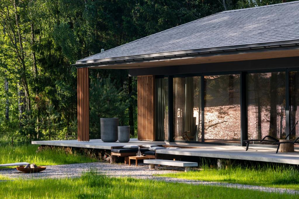 a pavilion with benches and tables in the grass at Villa The Lake in Mindūnai