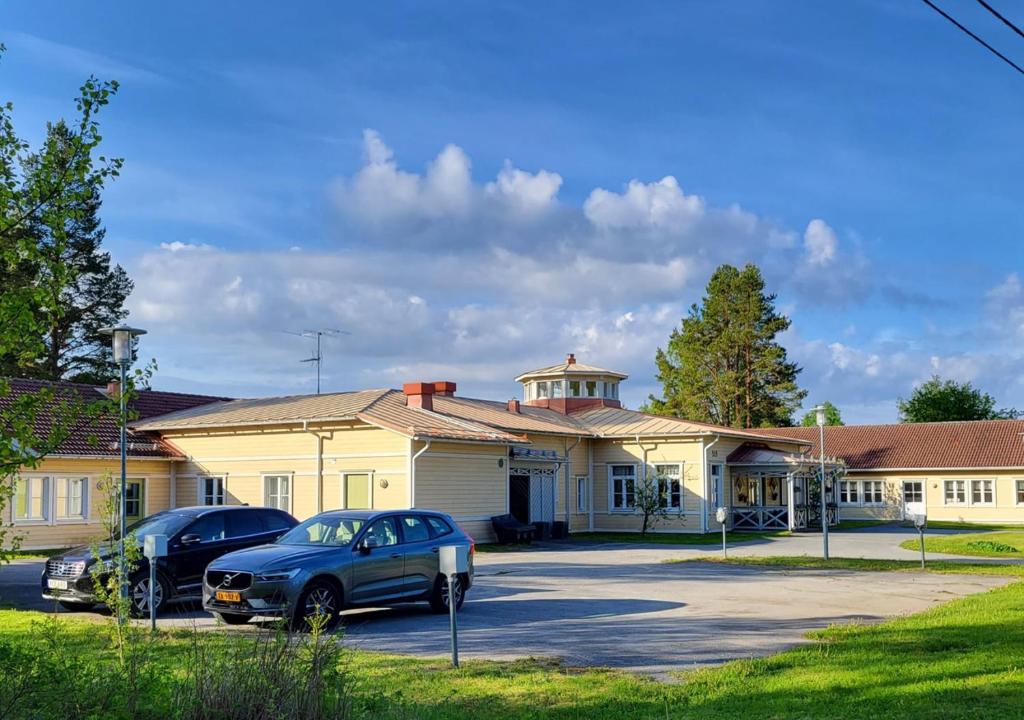 a building with two cars parked in front of it at HusHotellHunge AB in Bräcke
