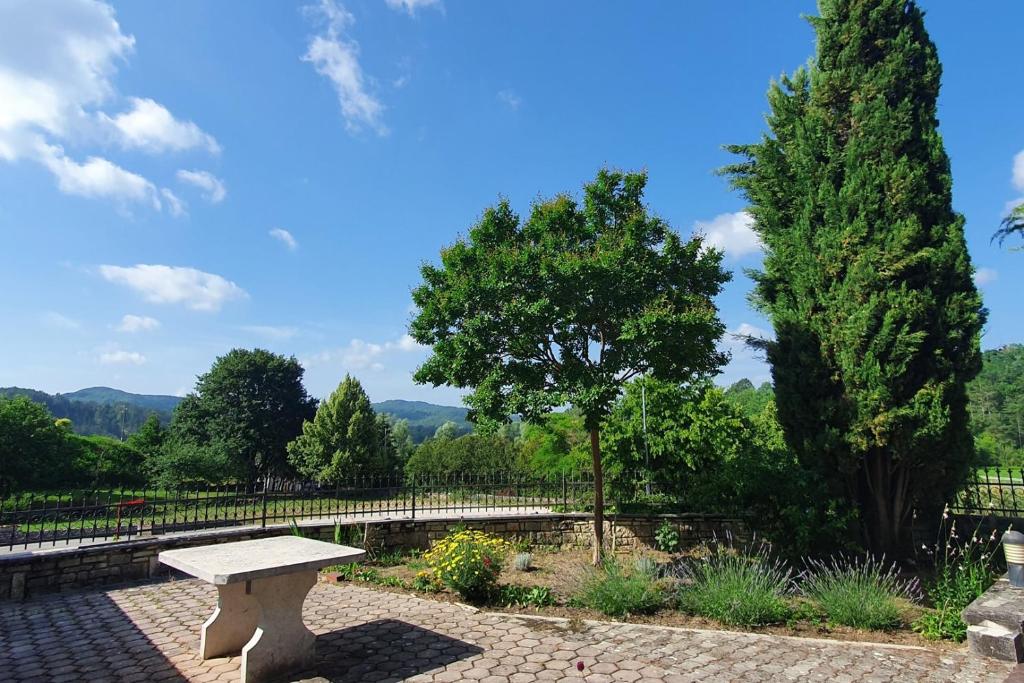 kamienna ławka siedząca w ogrodzie z drzewami w obiekcie Relaxing apartment Gardens for max 8 persons in green central Istria w mieście Novaki Pazinski