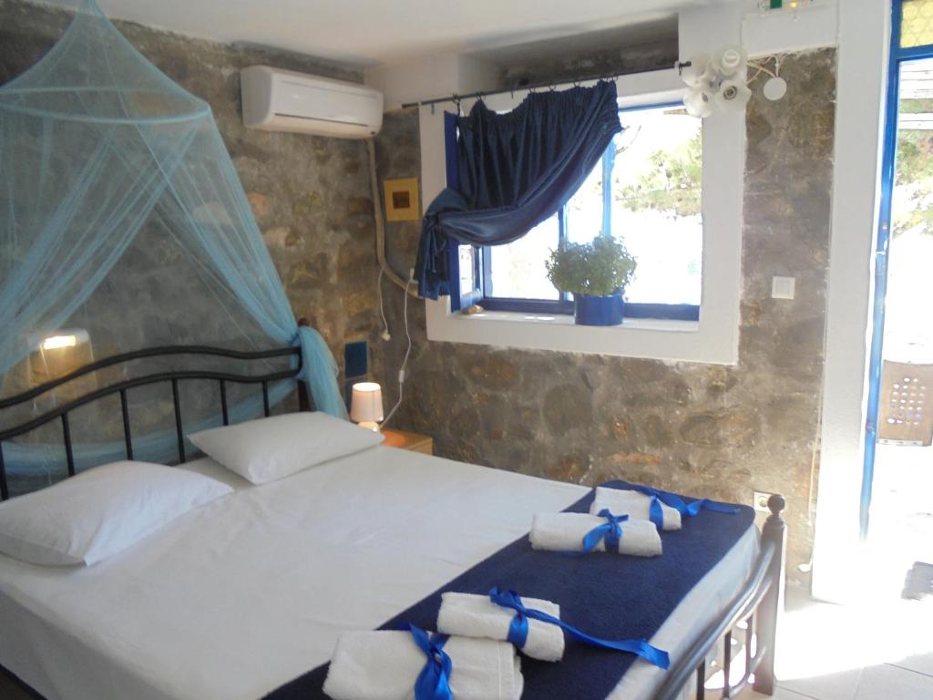 a bedroom with a bed with towels on it at Anatoli Studios in Skhoinoussa