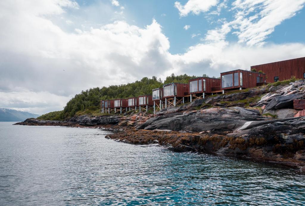 Lyngseidet的住宿－Aurora Fjord Cabins，一条在水体旁的轨道上的火车