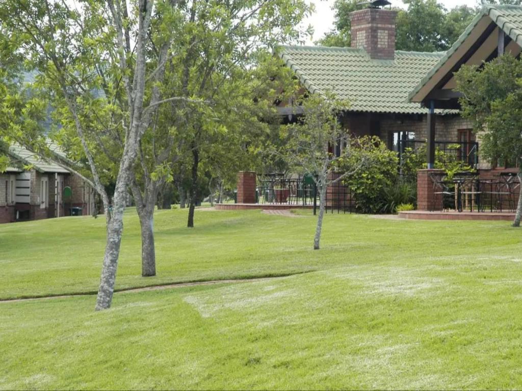 two trees in a yard in front of a house at FamilyQuest Accommodation in White River