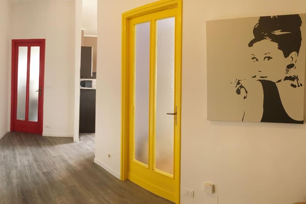 a yellow door in a room with a painting on the wall at Pop Apartment near Pala Alpitour in Turin