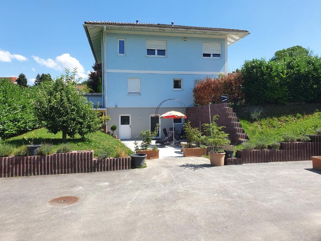 un edificio blu con molte piante davanti di Maison d'hôtes Bleu Cudrefin a Cudrefin