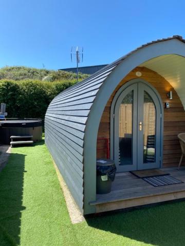 mały budynek z drzwiami w trawie w obiekcie The Pod w Aberystwyth