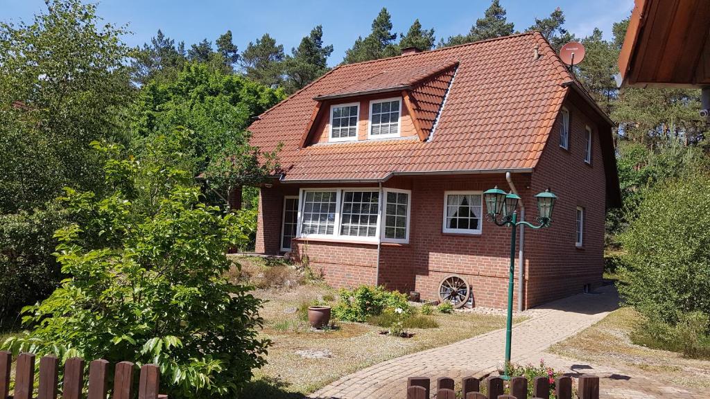 ein kleines Haus mit rotem Dach in der Unterkunft Ferienhaus am Waldrand Stedden in Stedden