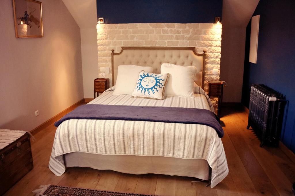 een slaapkamer met een groot bed met een bakstenen muur bij Domaine Gille in Comblanchien