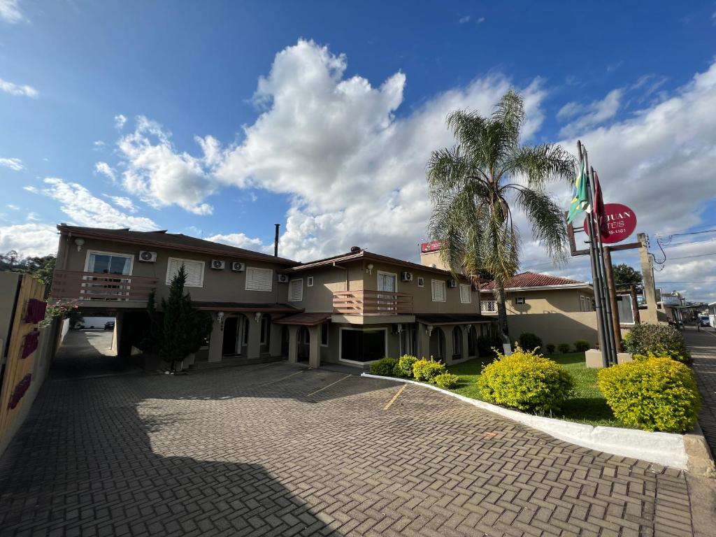 un hotel con una palmera y un edificio en San Juan Jaguariaiva en Jaguariaíva