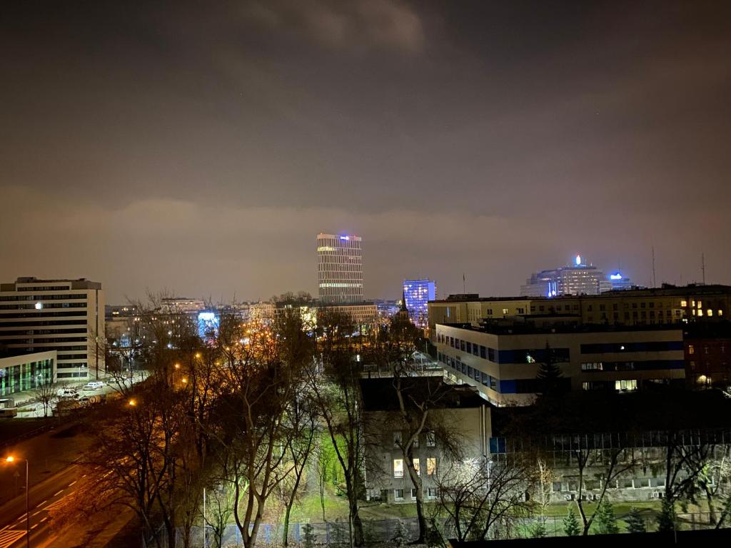 un perfil urbano por la noche con luces en los edificios en Brand New apartment in perfect location, en Varsovia