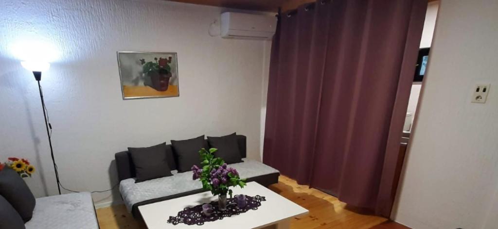 - un salon avec un canapé et une table fleurie dans l'établissement Vikendica DRINSKI DAR, à Mali Zvornik