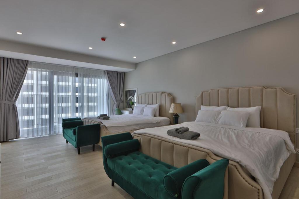 um quarto amplo com 2 camas e um sofá verde em HighSea GoldCoast Superview Apartment em Nha Trang