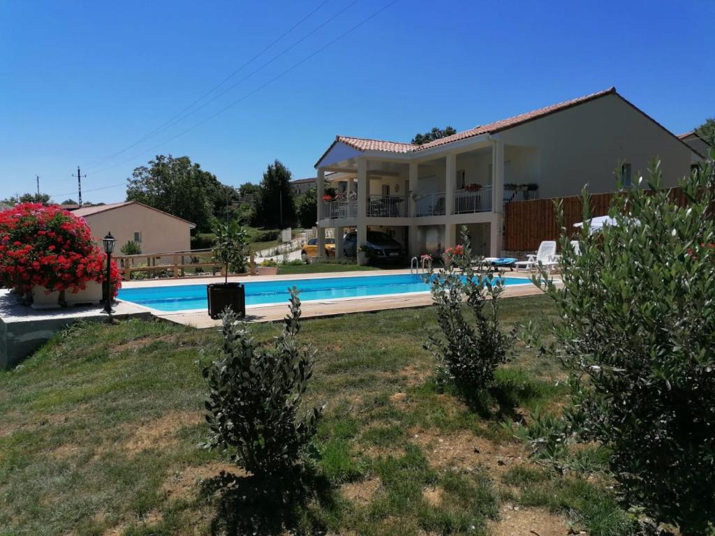 ein Haus mit einem Pool im Hof in der Unterkunft Villa Lembarrat vue sur côteaux jardin et piscine privée couverte, accès PMR facilité in Calignac