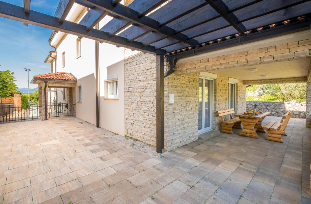 an outdoor patio with a wooden pergola at Apartment Tulipan in Klimno