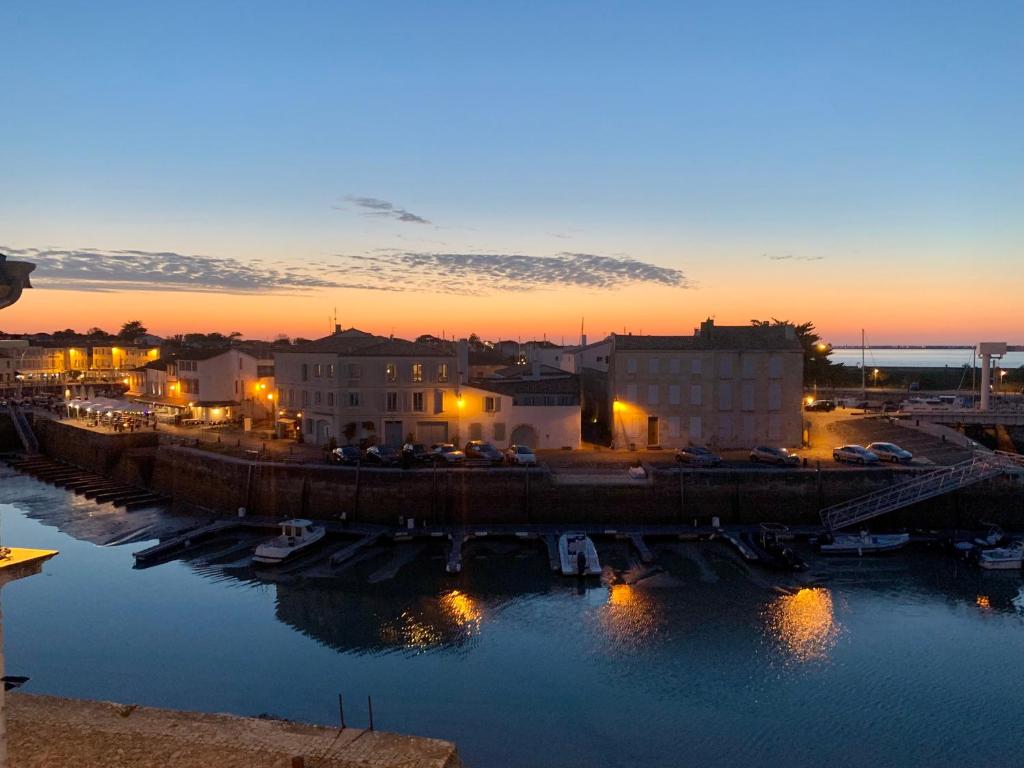 un coucher de soleil sur un port avec des bateaux dans l'eau dans l'établissement Île de Ré - T3 avec sublime vue mer - 80m2 - 4 à 6 pers, à Saint-Martin-de-Ré