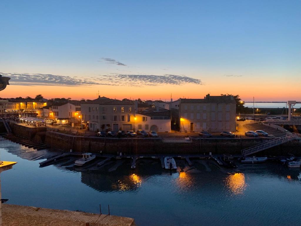 a sunset over a harbor with boats in the water at Île de Ré - T3 avec sublime vue mer - 80m2 - 4 à 6 pers in Saint-Martin-de-Ré