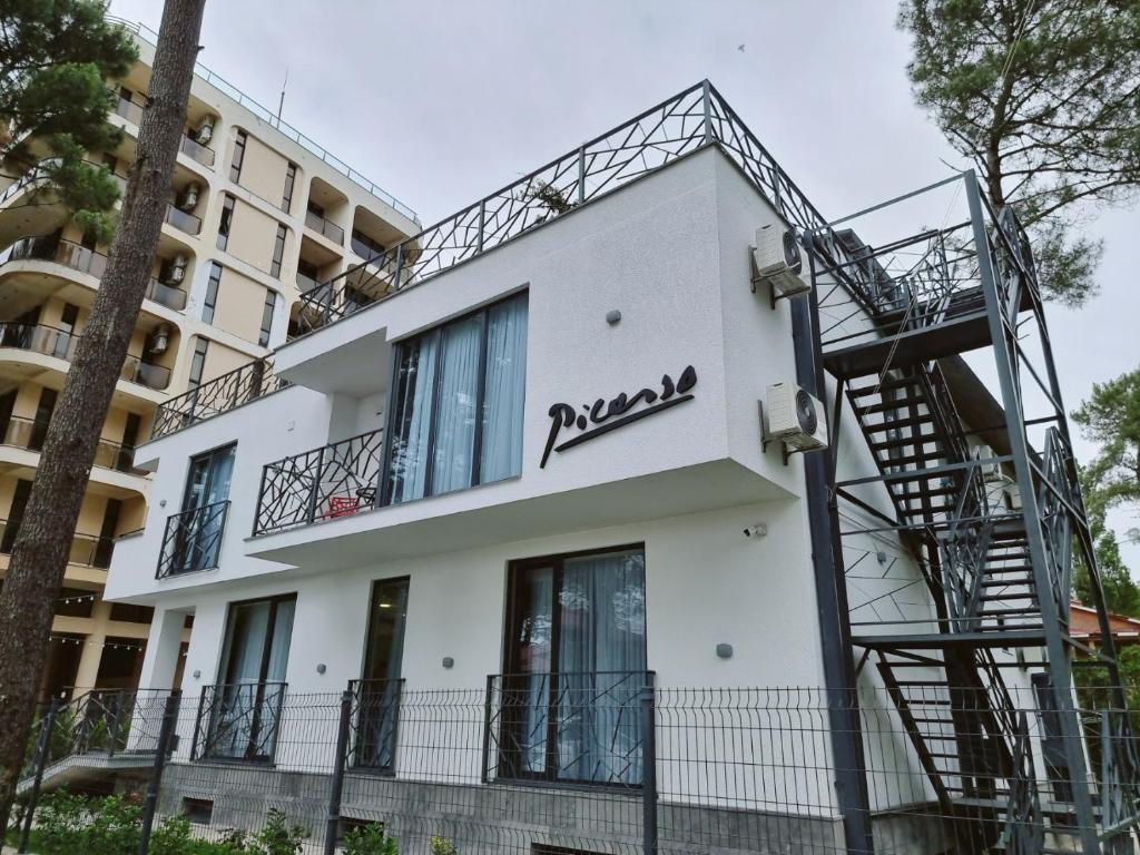 a white building with a spiral staircase on the side at Picasso in Shekvetili