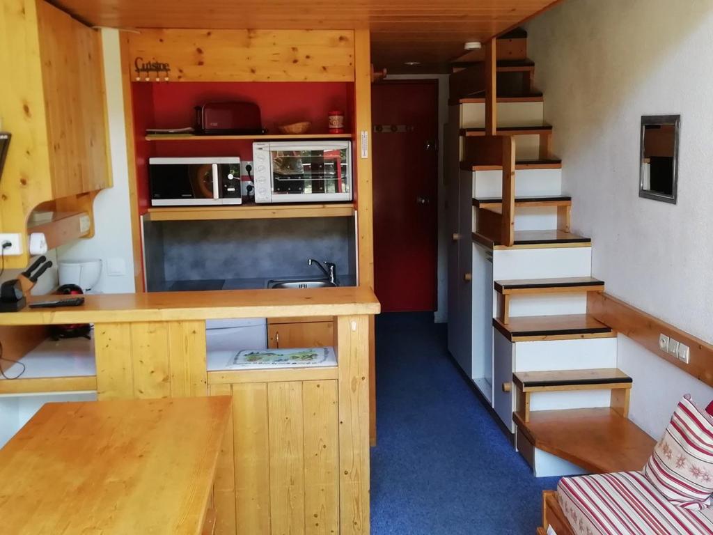 une petite maison avec une cuisine et un escalier dans l'établissement Duplex 2 pièces 5 pers, balcon sud, proche pistes et commerces, Animaux admis - Arc 1800 - FR-1-411-296, à Arc 1800