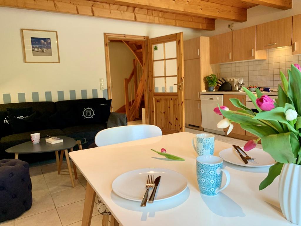 a kitchen and living room with a table and chairs at Ferienwohnung 1 im Böhler Haubarg in Sankt Peter-Ording