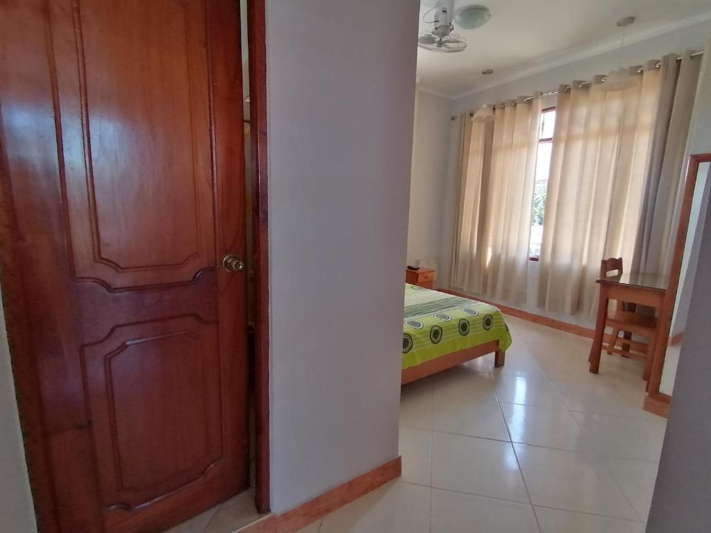 ein Schlafzimmer mit einer Tür und einem Bett in einem Zimmer in der Unterkunft Rosa Victoria in Tarapoto