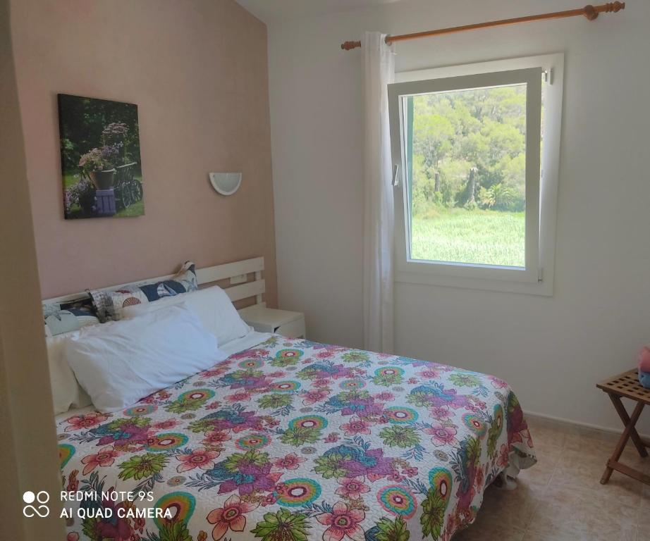 sypialnia z łóżkiem i oknem w obiekcie Menorca Cala Galdana w Cala Galdana