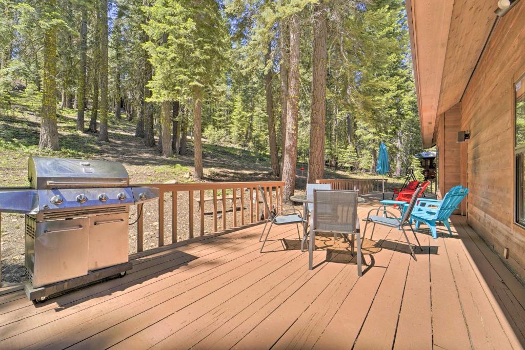 a patio with a grill and chairs on a wooden deck at Wraparound Deck and Pool Access Truckee Cabin in Truckee