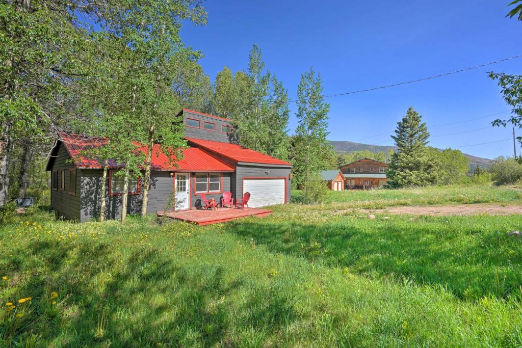 a house with a red roof in a field at Picturesque Creekside Cabin - Hike and Fish! in Cuchara