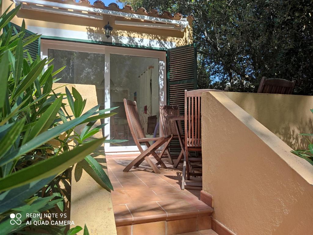 卡拉加爾達納的住宿－Menorca Cala Galdana，一个带椅子的庭院和滑动玻璃门
