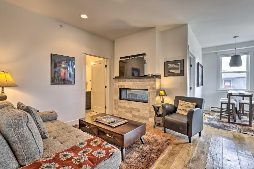 a living room with a couch and a fireplace at Grand Lake Condo with Balcony and Mountain Views in Grand Lake