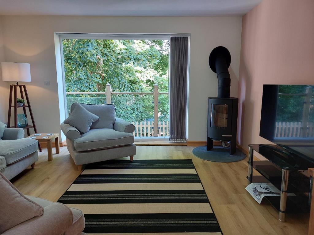 a living room with a couch and a chair and a television at Two bedroom cottage - country lane -10 min walk to Perranporth beach in Perranporth