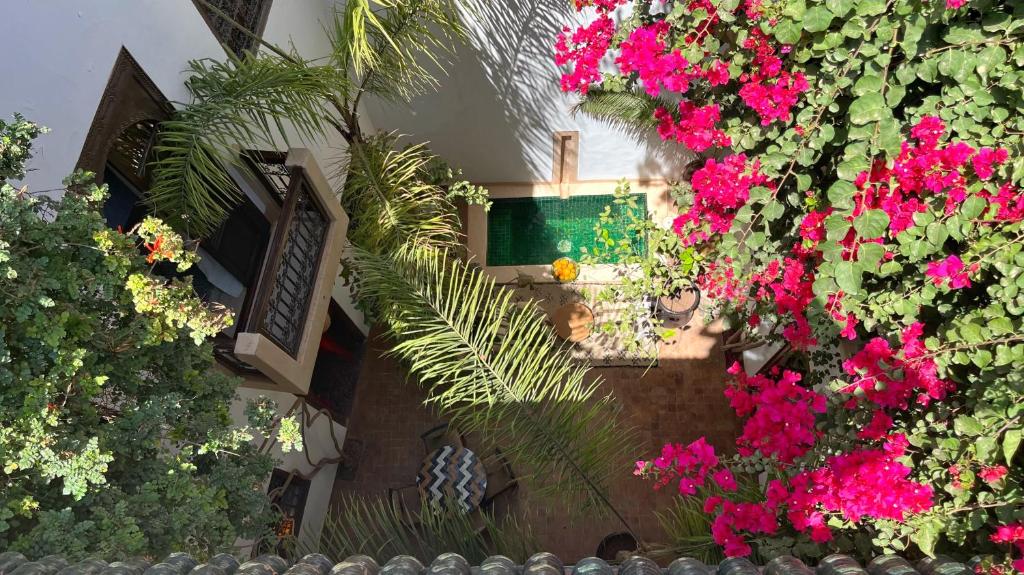 una vista aérea de un jardín con flores rosas en Riad Dar Zaman en Marrakech