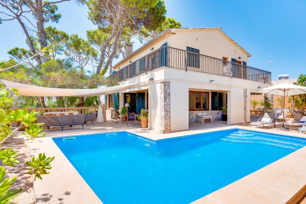 a villa with a swimming pool in front of a house at Villa Cala Estancia Mercedes by PriorityVillas in Palma de Mallorca