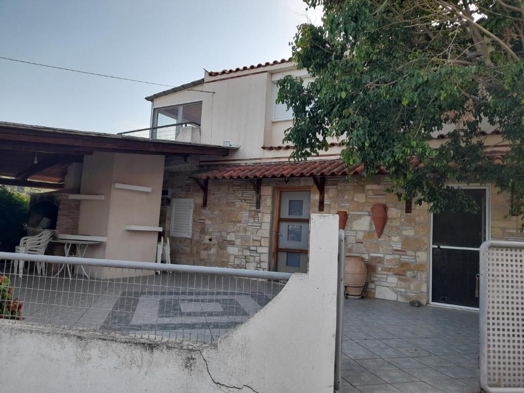 a house with a fence in front of it at Cosy maisonette close to Poros,Epidauros,Nafplio in Taktikoúpolis