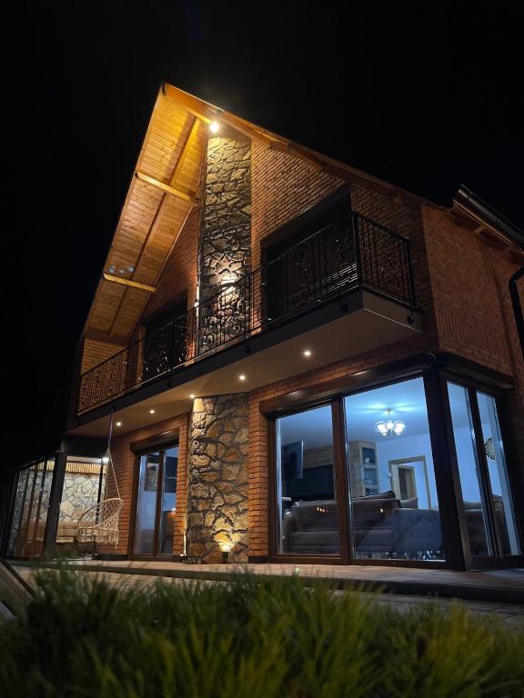 a building with a balcony on the side of it at night at Villa Ozoni - Jezerc in Ferizaj