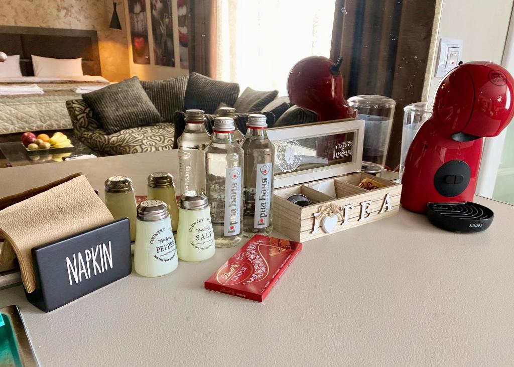 a counter top with bottles and a red pimpimp at Luxury Apartments Ivon in Plovdiv