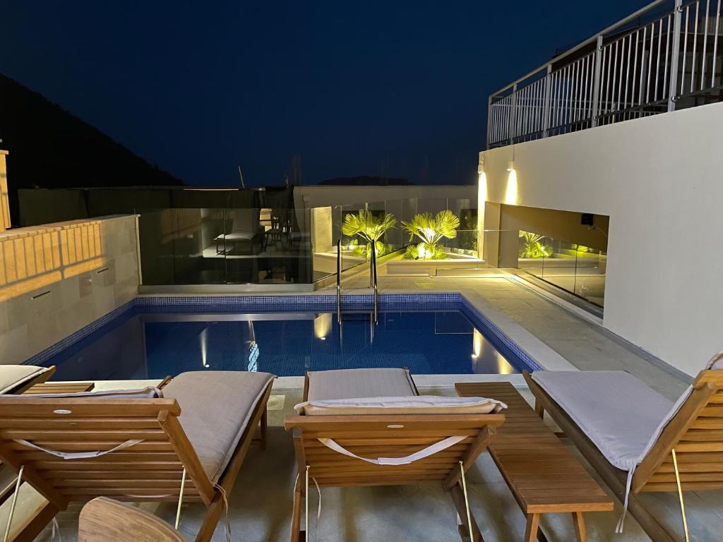 een zwembad met ligstoelen en een huis bij Vistamar Hotel & Apartments in Budva