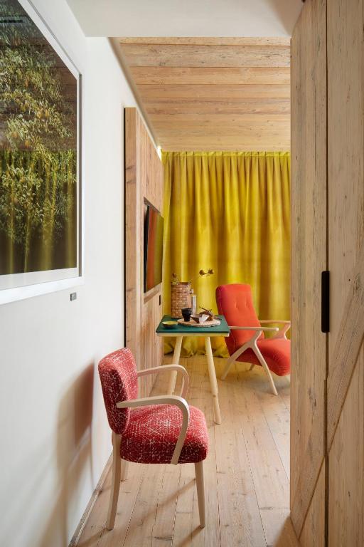 a living room with two chairs and a table at HOTEL de LEN in Cortina dʼAmpezzo