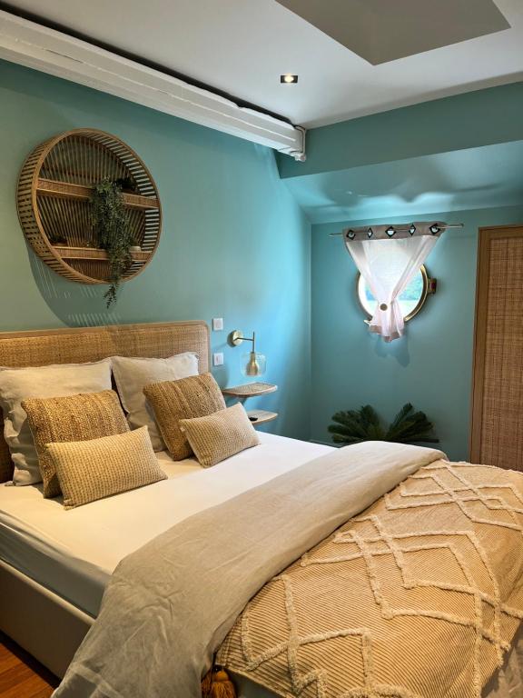 a bedroom with a large bed with blue walls at Péniche Santa Julia au port de Chantilly Insolys in Saint-Leu-dʼEsserent