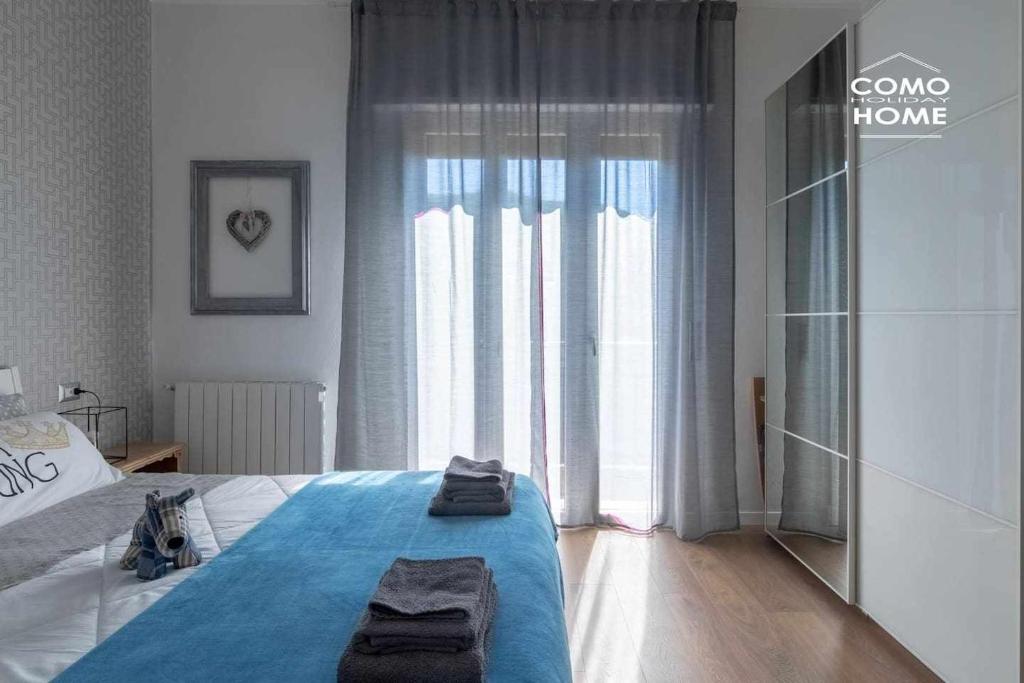 Como Holiday Home Appartamento ideale per famiglie في كومو: غرفة نوم بسرير ونافذة كبيرة