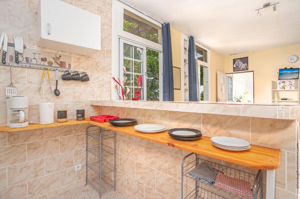 una cucina con bancone e piatti di Appartement La Source -Calme avec belle vue mer a Les Trois-Îlets