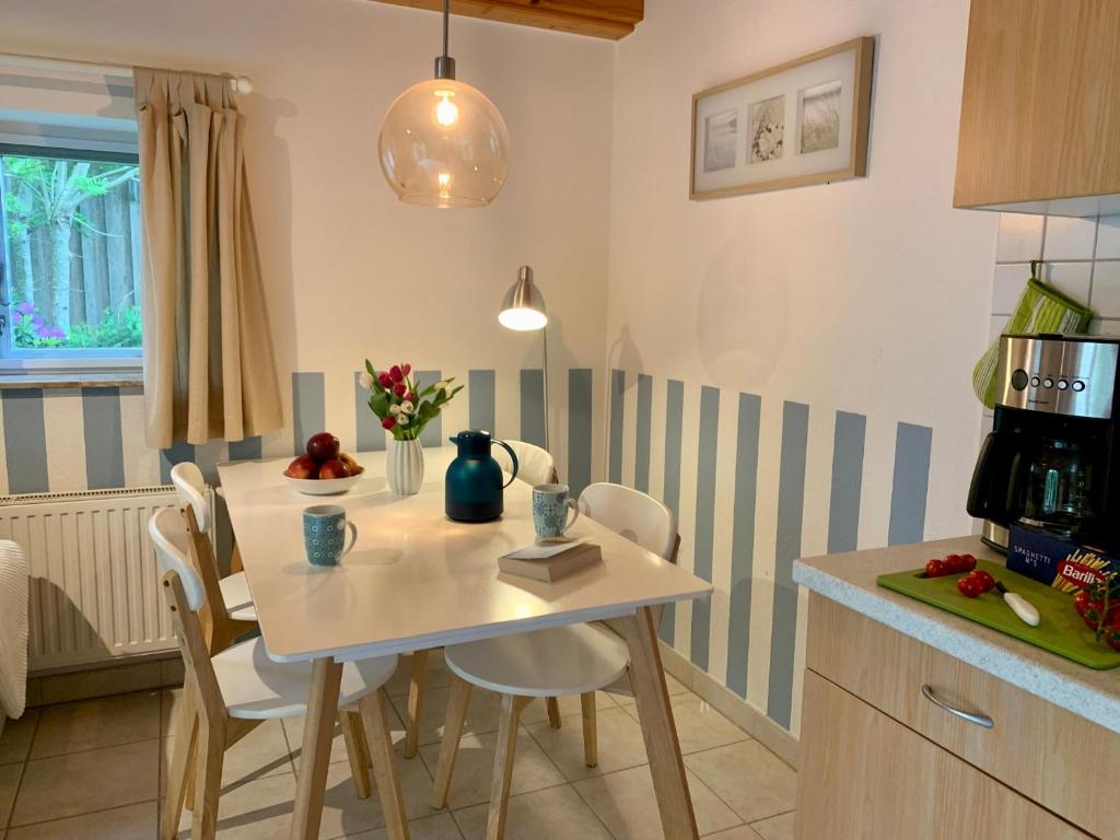 a kitchen with a white table and chairs in a room at Ferienwohnung 5 im Böhler Haubarg in Sankt Peter-Ording