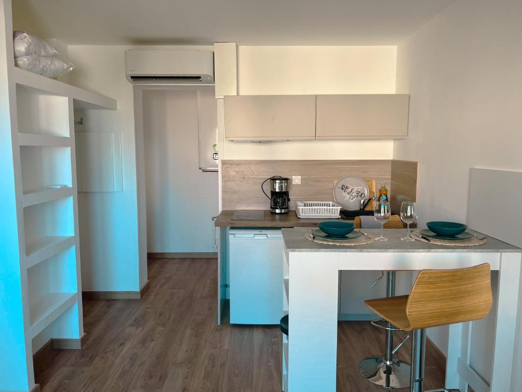 uma cozinha com armários azuis e brancos e um balcão em Studio Roncu em Calvi