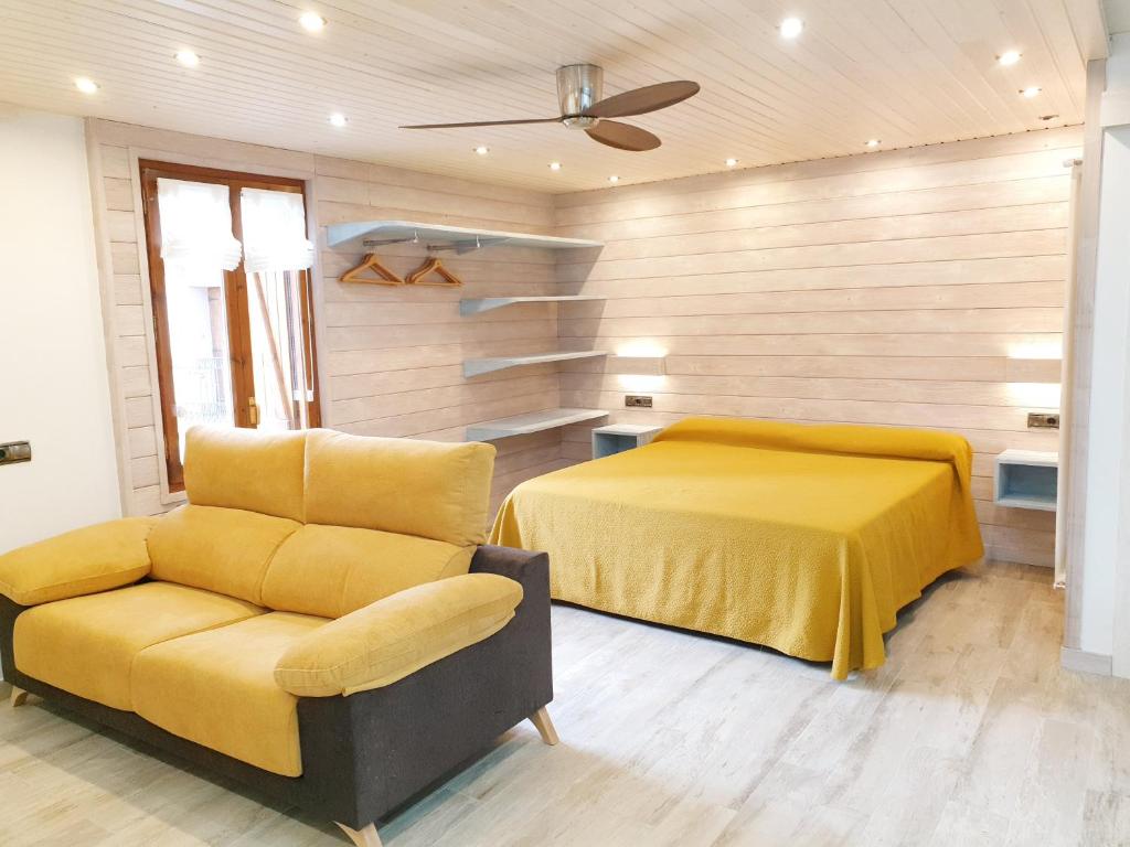 1 dormitorio con 1 cama amarilla y 1 silla en Apartamentos Casa Patro, en Tramacastilla de Tena